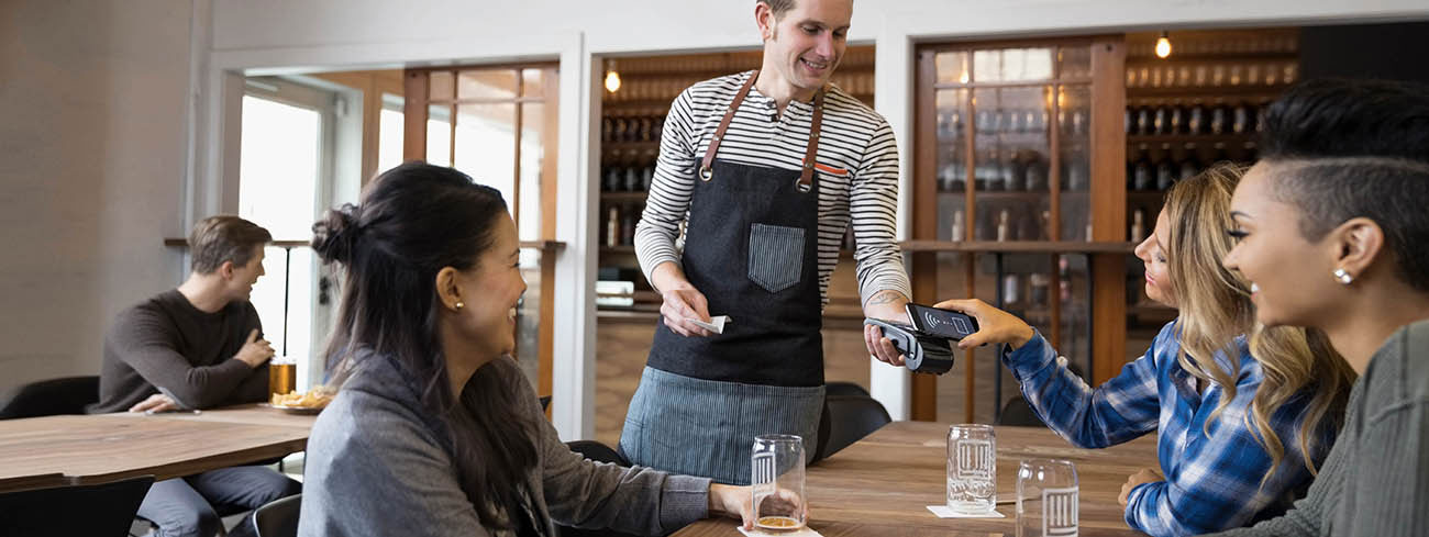 Personen in einem Resturant die gerade zahlen